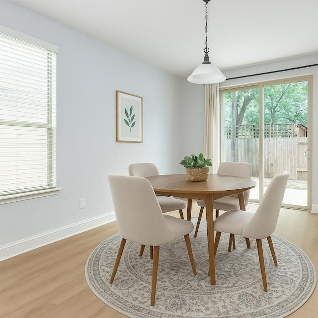 dining space featuring baseboards and light wood-style flooring