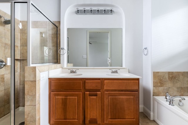 full bathroom with a sink, a bath, a stall shower, and double vanity