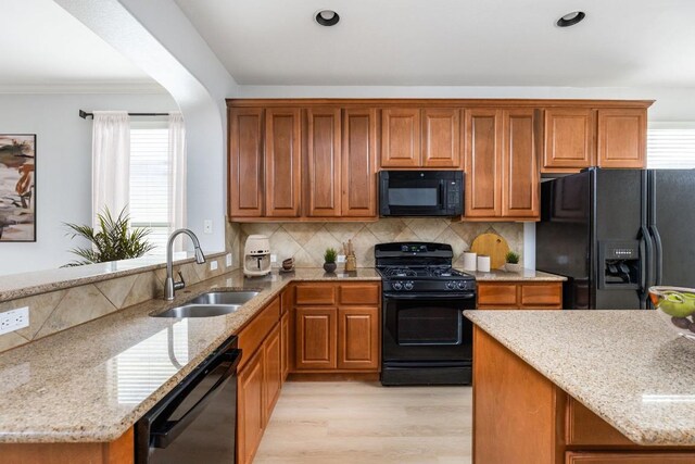 2509 Lightfoot Trl, Austin, TX 78745 - kitchen with black appliances, light stone countertops, brown cabinets, recessed lighting, and crown molding