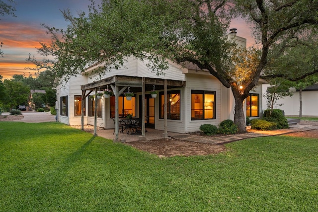 back of property featuring a lawn and a patio