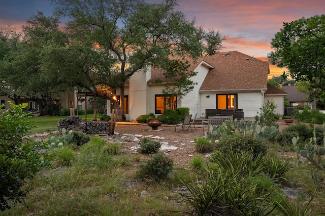 back of property featuring a patio area and roof with shingles