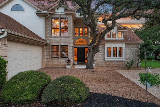 view of front of house featuring brick siding and a garage