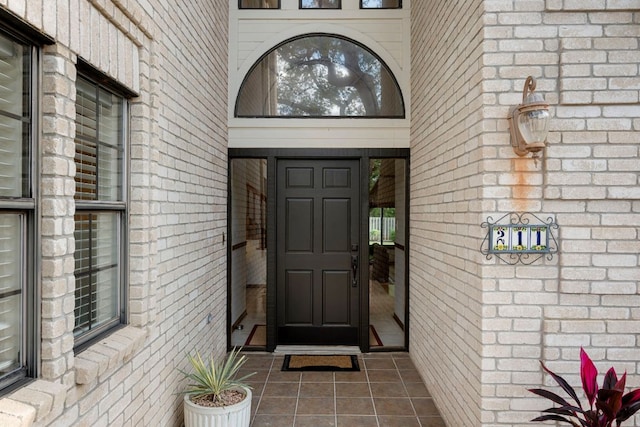 doorway to property featuring brick siding