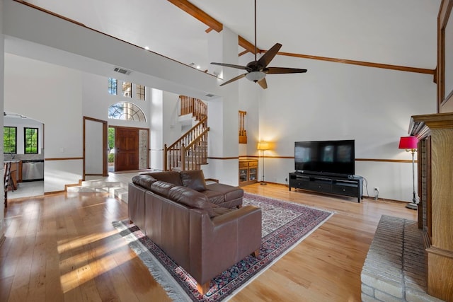 living area with visible vents, stairs, hardwood / wood-style floors, and high vaulted ceiling