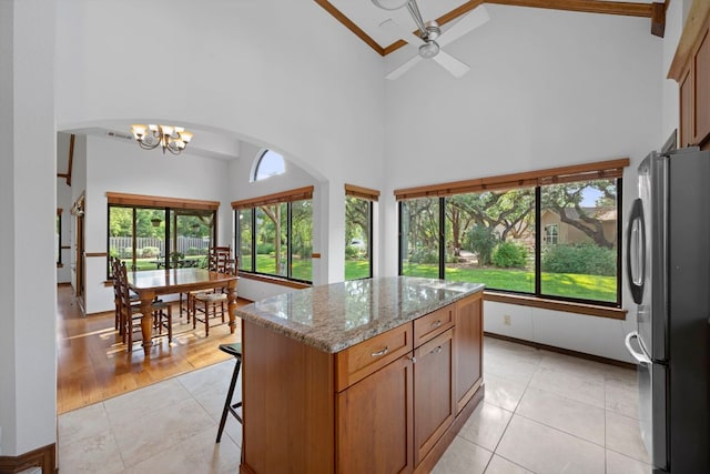 kitchen with freestanding refrigerator, high vaulted ceiling, and a healthy amount of sunlight