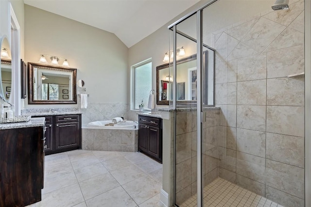 full bathroom with vaulted ceiling, tile patterned floors, a shower stall, and a garden tub