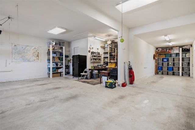 garage with freestanding refrigerator and a ceiling fan