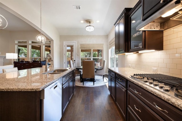 kitchen featuring exhaust hood, dark wood-style flooring, a sink, light stone counters, and dishwashing machine