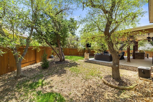 view of yard with an outdoor living space, a fenced backyard, ceiling fan, and a patio area