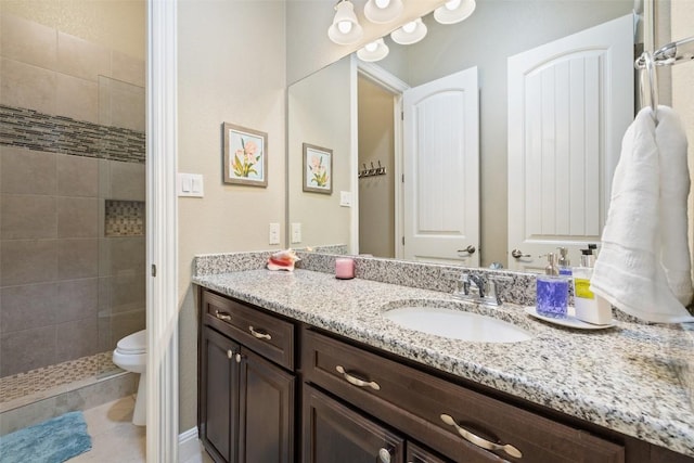 full bath featuring vanity, tile patterned floors, a tile shower, and toilet