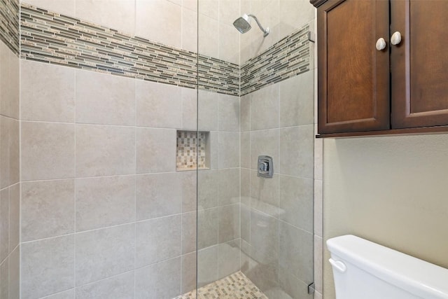 full bath with toilet and tiled shower