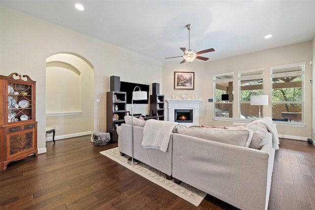 5217 Cedro Elm Dr, Austin, TX 78738 - living room featuring a ceiling fan, dark wood-style flooring, a warm lit fireplace, and recessed lighting