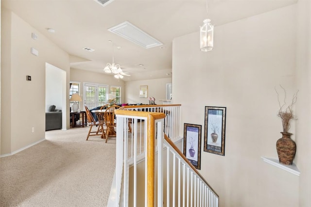 interior space featuring visible vents, baseboards, attic access, light colored carpet, and an upstairs landing