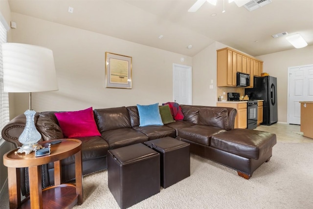 living area featuring a ceiling fan, light colored carpet, visible vents, and vaulted ceiling