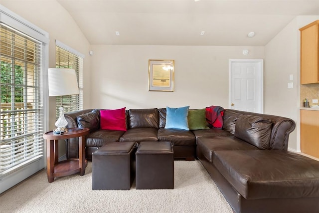 living area featuring light colored carpet and lofted ceiling