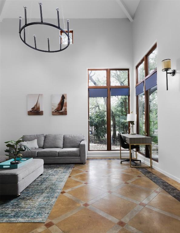 living area with a high ceiling and a notable chandelier