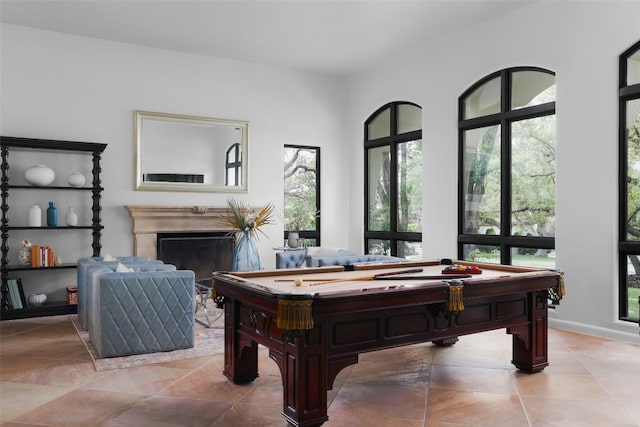 playroom with light tile patterned flooring, pool table, and a high end fireplace