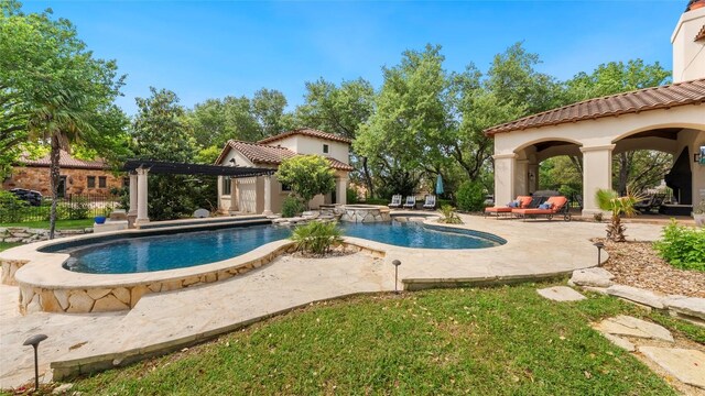 view of pool featuring a patio, a pool with connected hot tub, and an outdoor structure