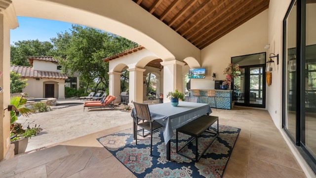 view of patio featuring outdoor dining area and exterior fireplace