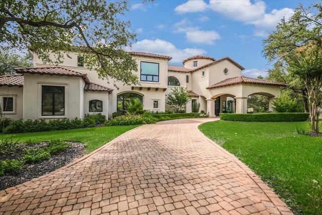 201 Costa Bella Dr, Austin, TX 78734 - mediterranean / spanish house featuring stucco siding, a tile roof, a front lawn, and decorative driveway