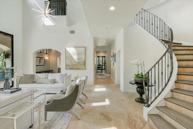 201 Costa Bella Dr, Austin, TX 78734 - living room with arched walkways, a high ceiling, stairway, and recessed lighting