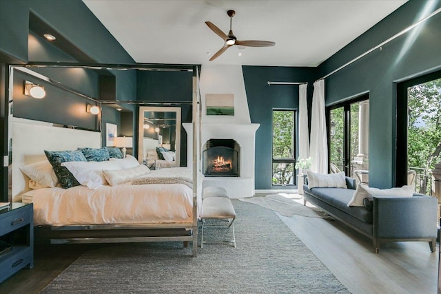 201 Costa Bella Dr, Austin, TX 78734 - bedroom with wood finished floors, a large fireplace, and ceiling fan