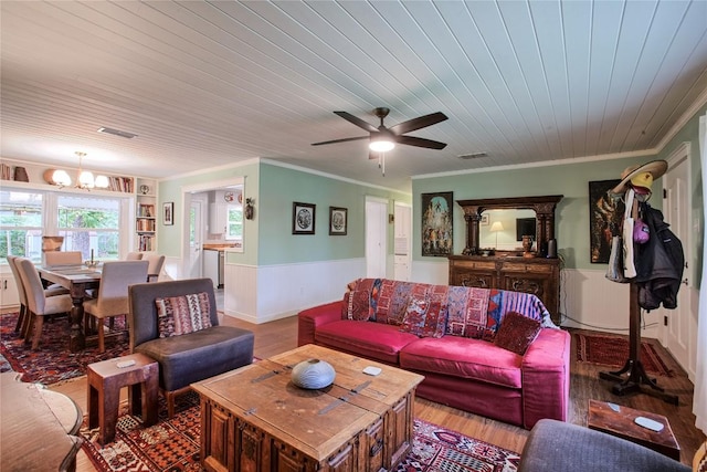 living area featuring crown molding, wainscoting, and visible vents