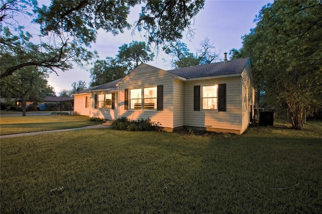 bungalow-style house with central AC unit and a front yard