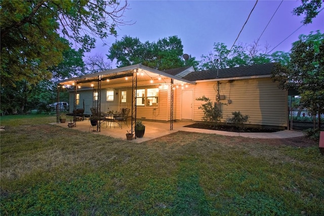 rear view of house featuring a yard and a patio