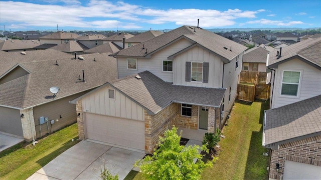 view of front facade featuring a residential view, board and batten siding, concrete driveway, and roof with shingles