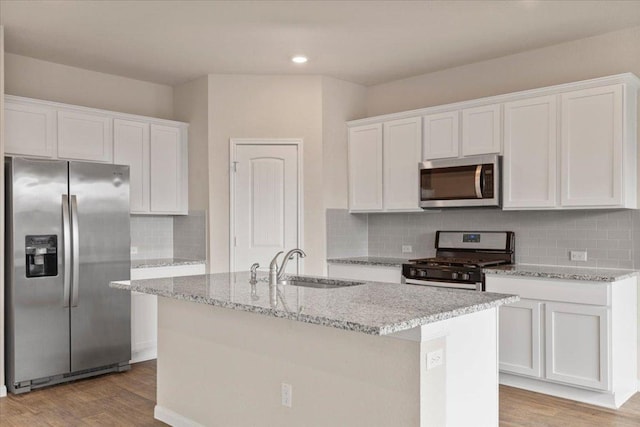 kitchen with a sink, stainless steel appliances, and white cabinetry