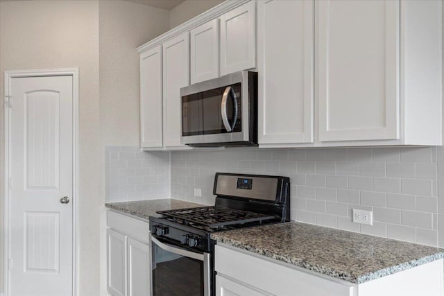 kitchen featuring tasteful backsplash, light stone countertops, stainless steel appliances, and white cabinets