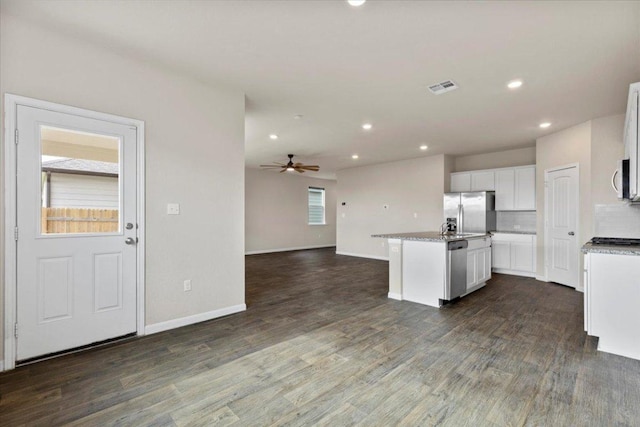 kitchen featuring ceiling fan, appliances with stainless steel finishes, a kitchen island with sink, open floor plan, and visible vents