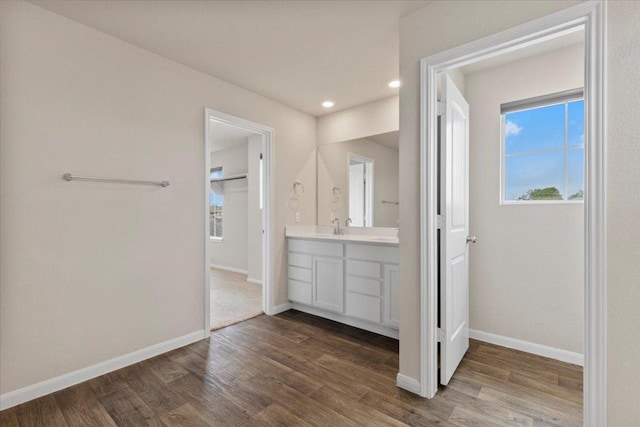 bathroom featuring recessed lighting, baseboards, wood finished floors, and vanity