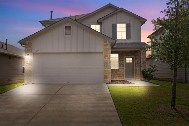 traditional-style home featuring a front yard, stone siding, board and batten siding, an attached garage, and driveway