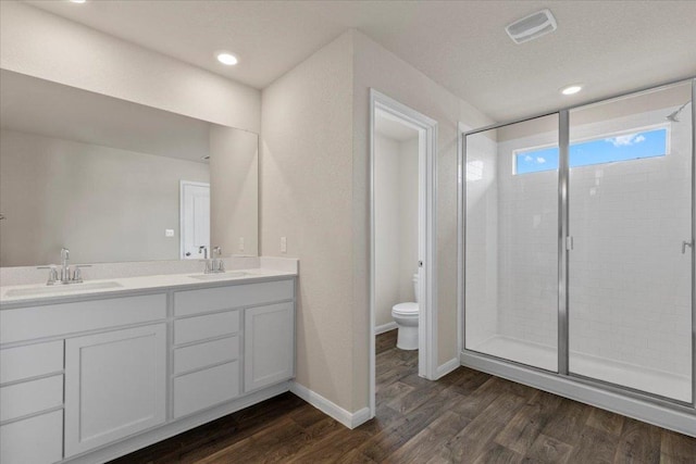 full bath with wood finished floors, toilet, a sink, and a stall shower