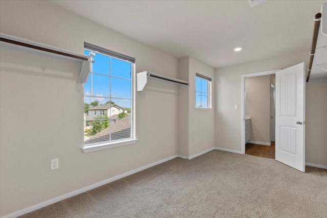 unfurnished bedroom with baseboards, recessed lighting, and carpet