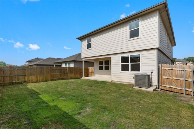 back of house with central AC unit, a patio area, a fenced backyard, and a yard