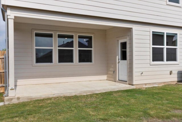 doorway to property with a patio area, fence, and a yard