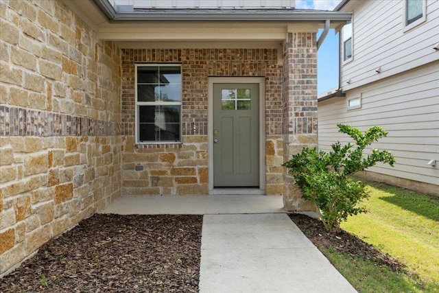 entrance to property featuring brick siding and stone siding