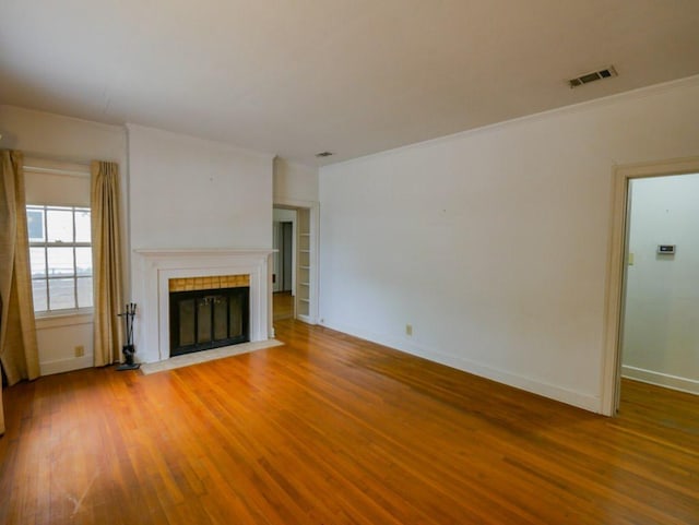 810 E 45th St, Austin, TX 78751 - unfurnished living room with visible vents, baseboards, wood finished floors, and a tile fireplace