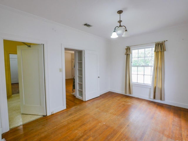 810 E 45th St, Austin, TX 78751 - unfurnished room with baseboards, a notable chandelier, visible vents, and wood finished floors