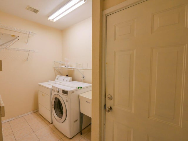 810 E 45th St, Austin, TX 78751 - laundry area with washing machine and dryer and light tile patterned flooring