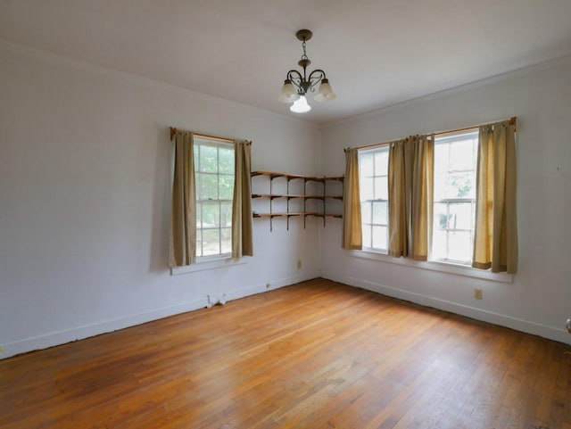 810 E 45th St, Austin, TX 78751 - spare room with crown molding, baseboards, light wood-style floors, and a notable chandelier