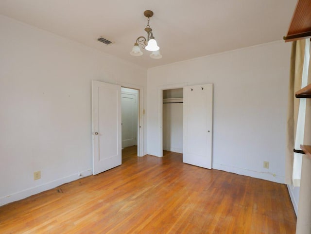 810 E 45th St, Austin, TX 78751 - unfurnished bedroom with a chandelier, light wood-style flooring, and a closet