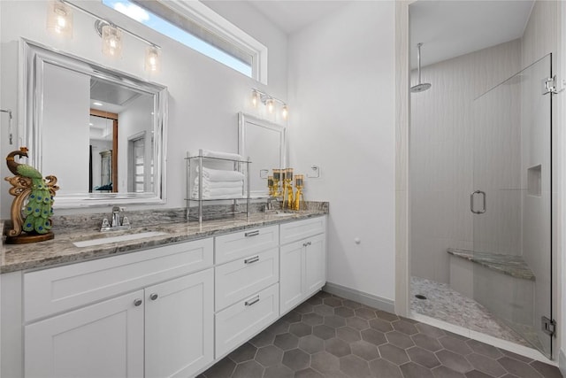 bathroom featuring double vanity, a sink, tile patterned flooring, and a stall shower