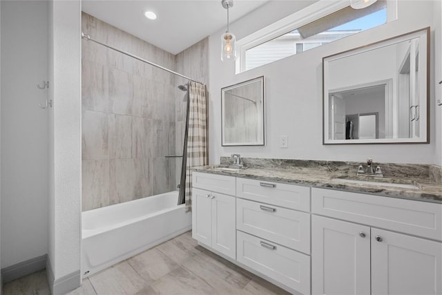 bathroom with double vanity, a sink, and shower / bath combo
