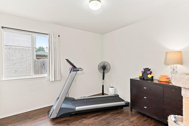 workout area featuring baseboards and wood finished floors