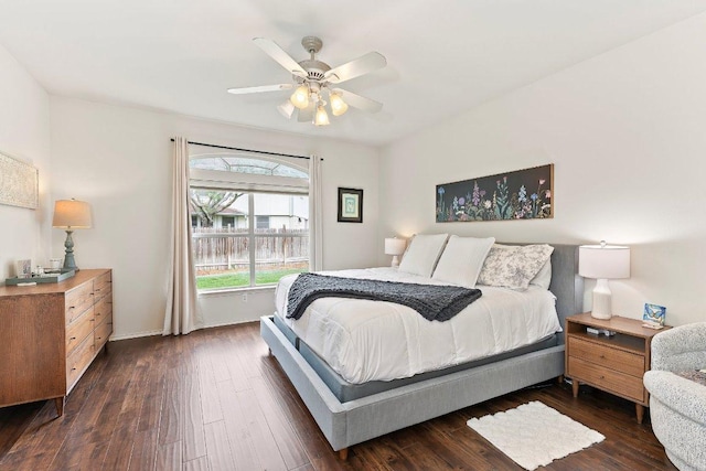 bedroom featuring a ceiling fan, baseboards, and dark wood finished floors