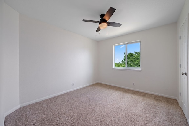 empty room featuring baseboards, ceiling fan, and light colored carpet